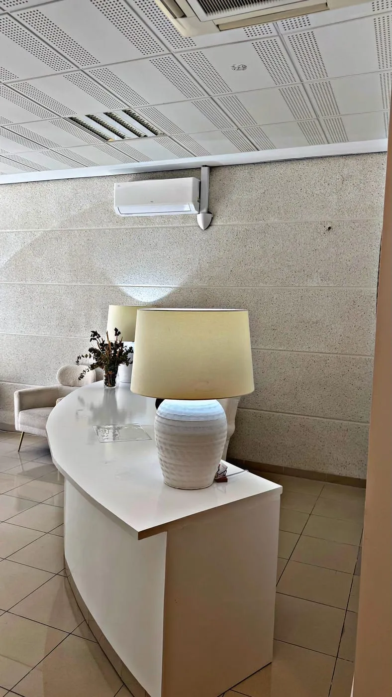 Mostrador de recepción blanco con lámparas